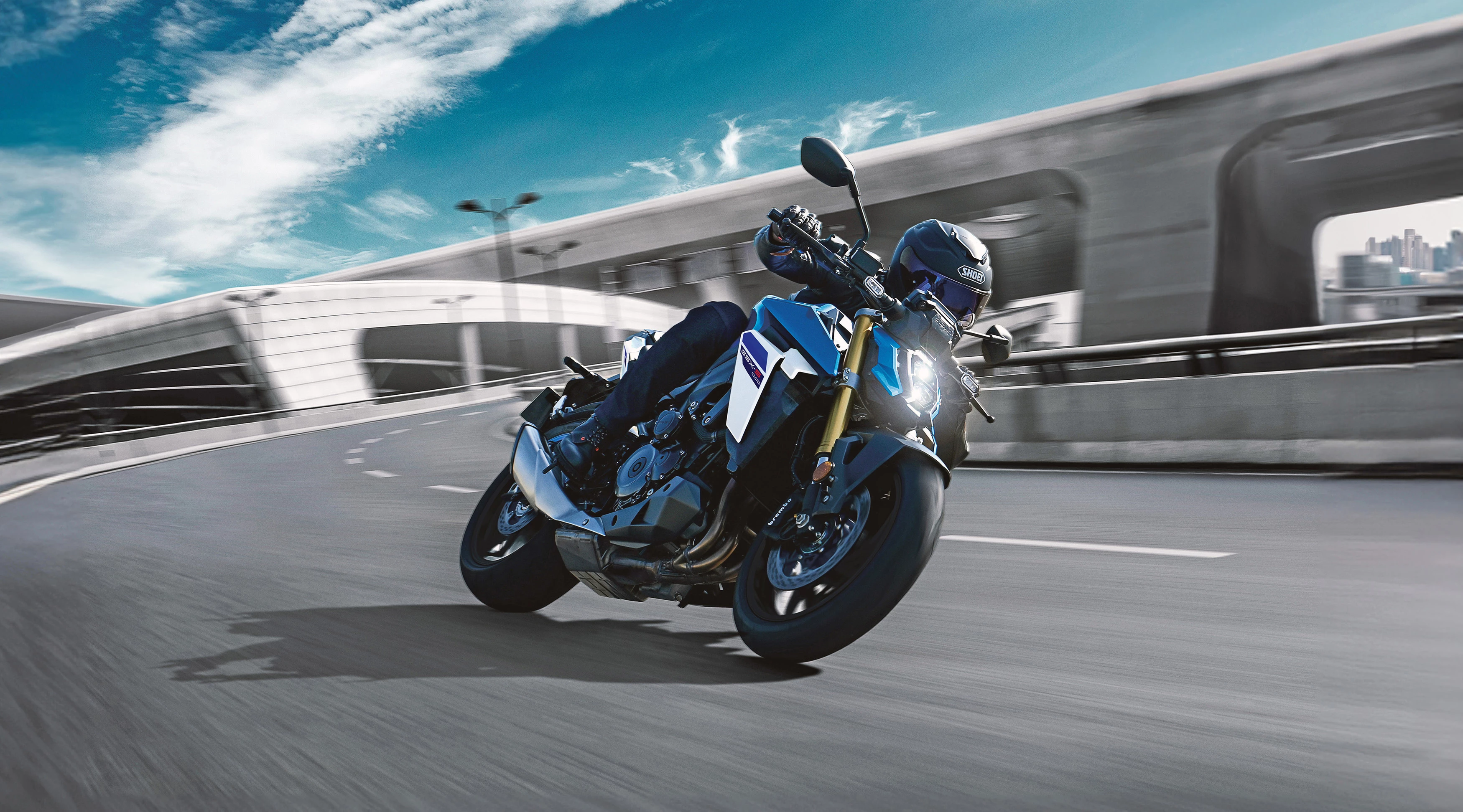 Suzuki GSX-S1000 in action on a curved road, demonstrating its agility and dynamic performance.