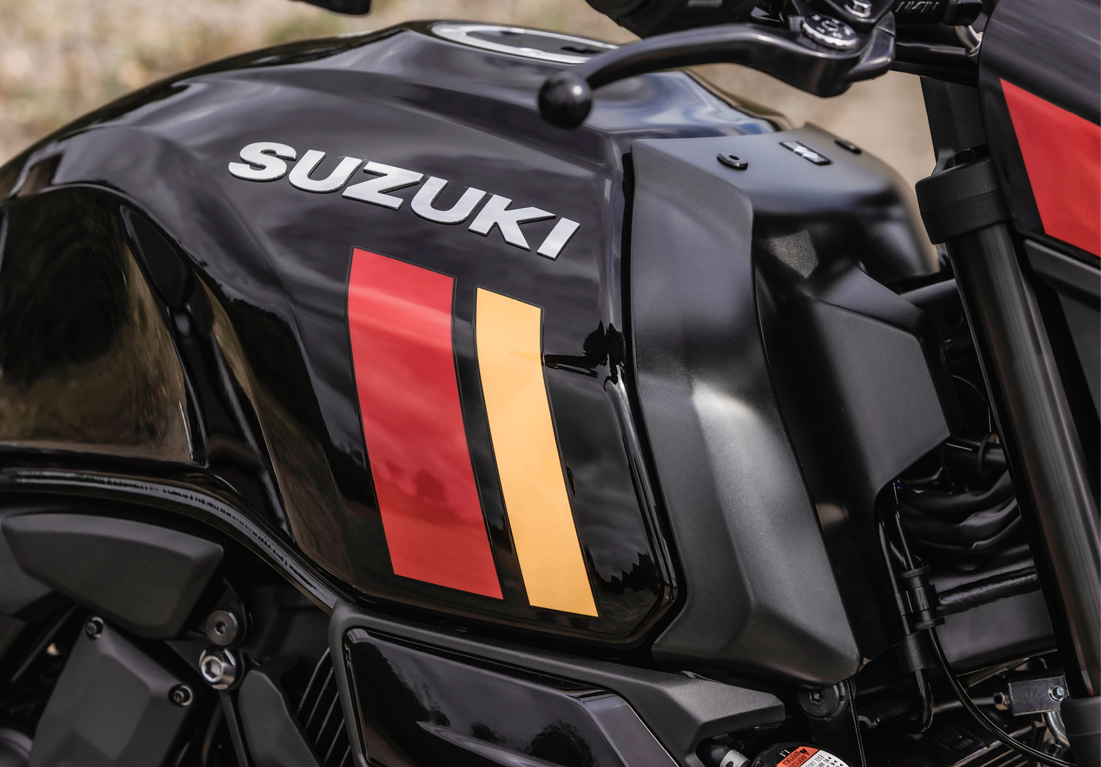 Suzuki GSX-8TT fuel tank close up, black colour scheme with red and yellow flashes