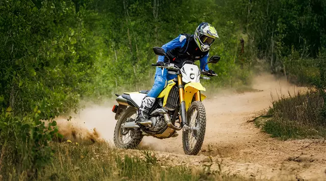 Suzuki DR-Z4S pushing on heading along a dirt track.