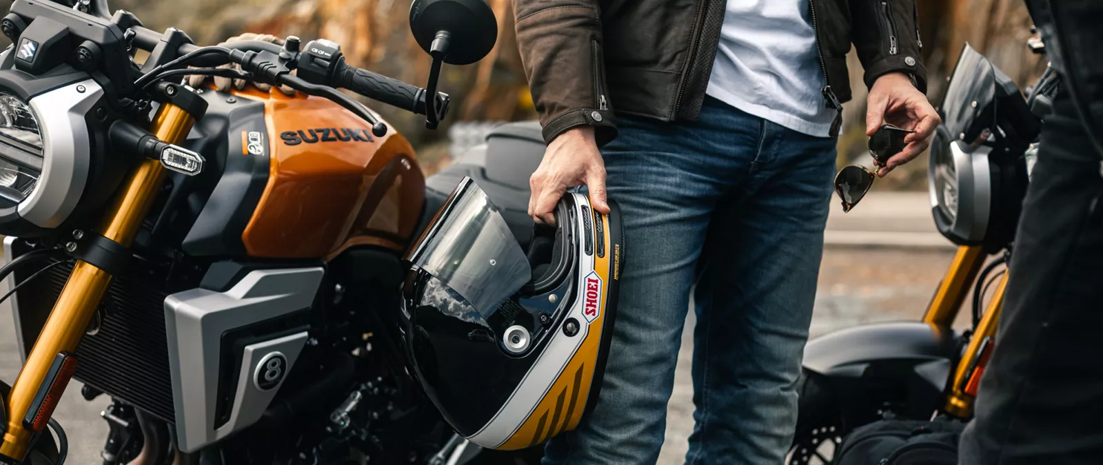 Suzuki GSX-8T gold, right hand side tank static with rider holding helmet next to the bike