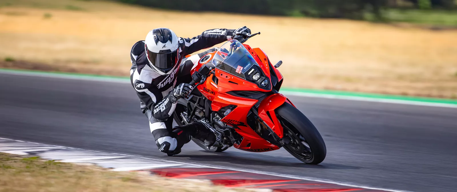 Suzuki GSX-8R orange leaning hard into a corner out on track
