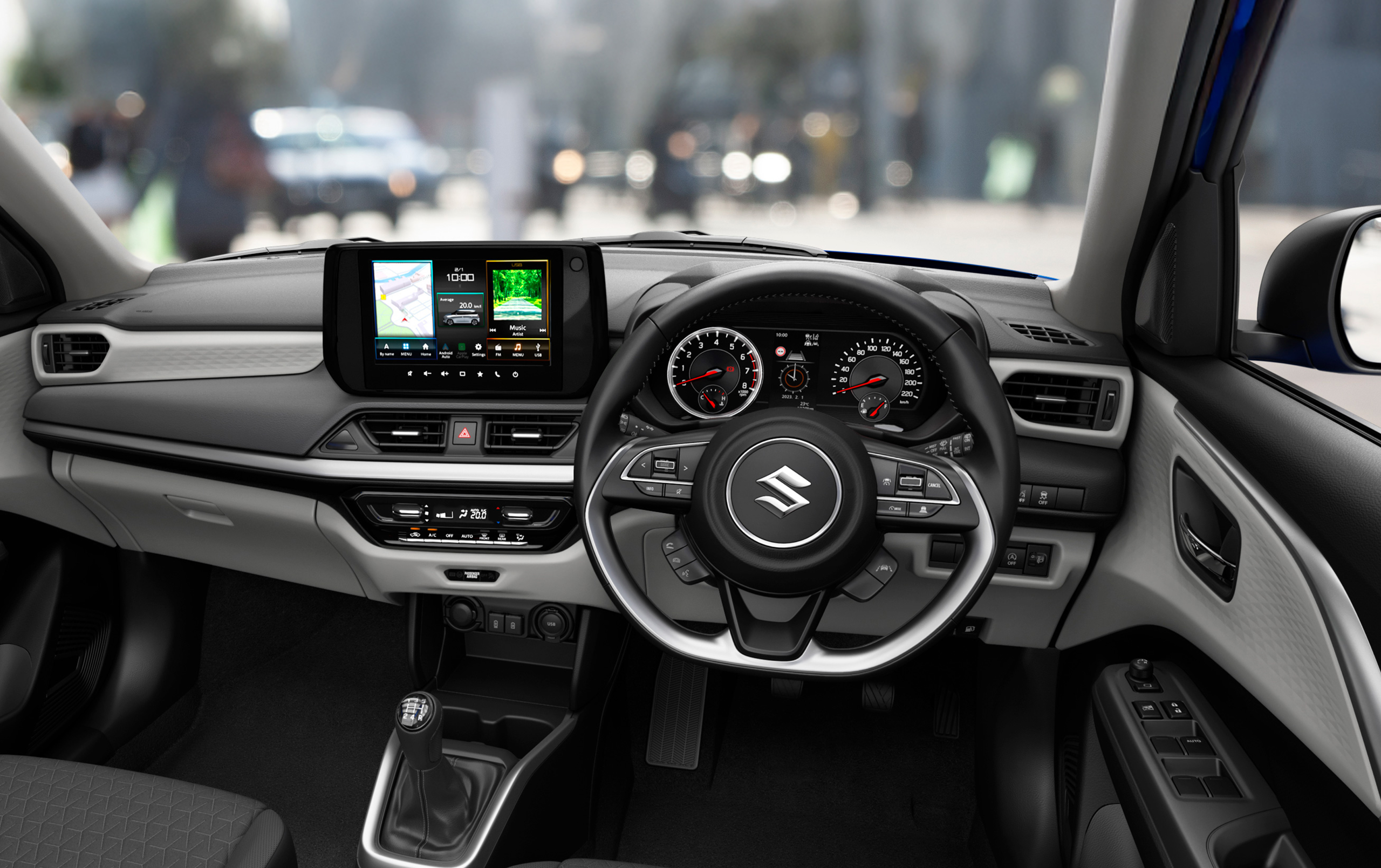 Interior view of the Suzuki Swift showcasing the 9-inch multimedia display, steering wheel controls, and modern dashboard layout