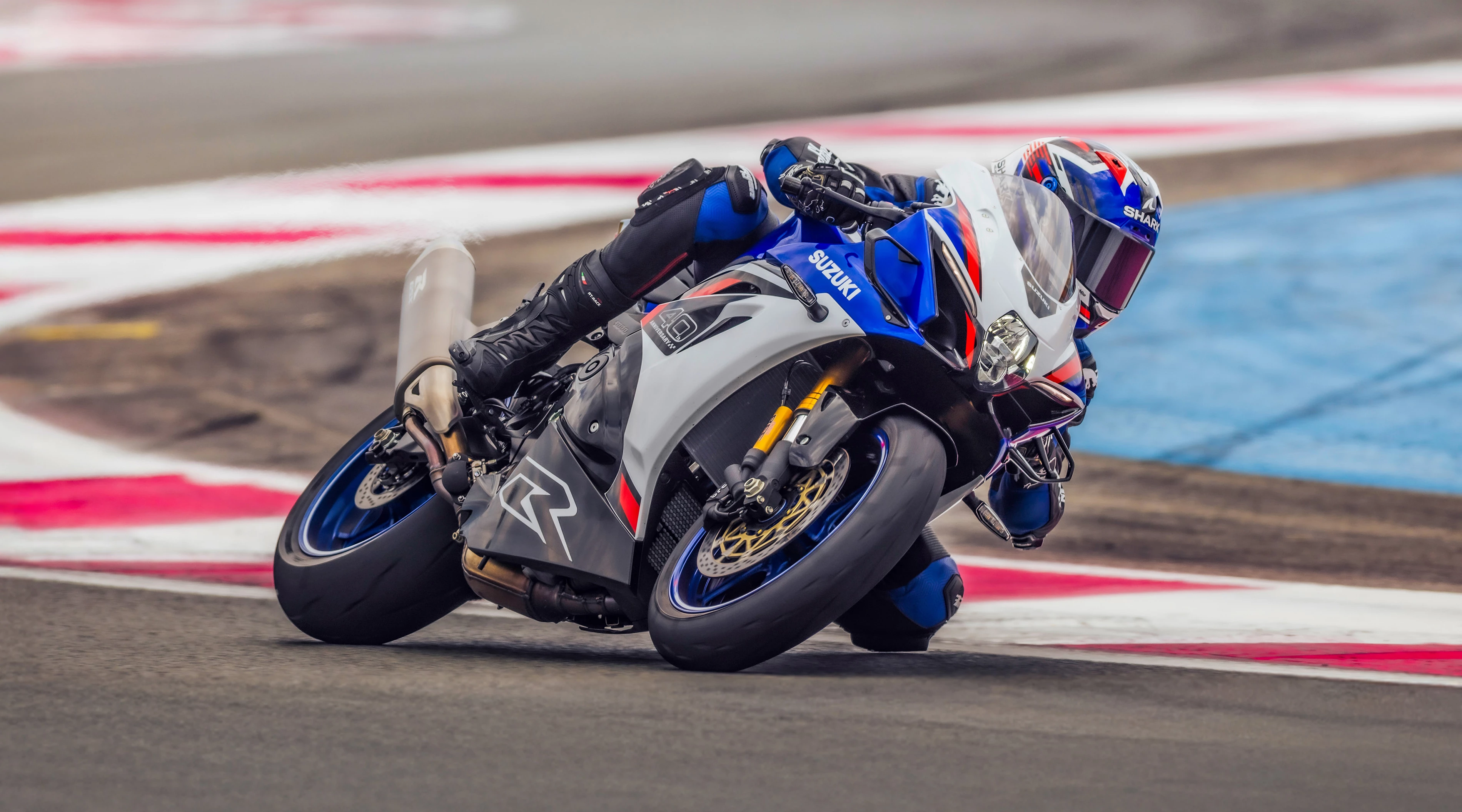 Suzuki GSX-R1000R leaning hard into a corner out on track.