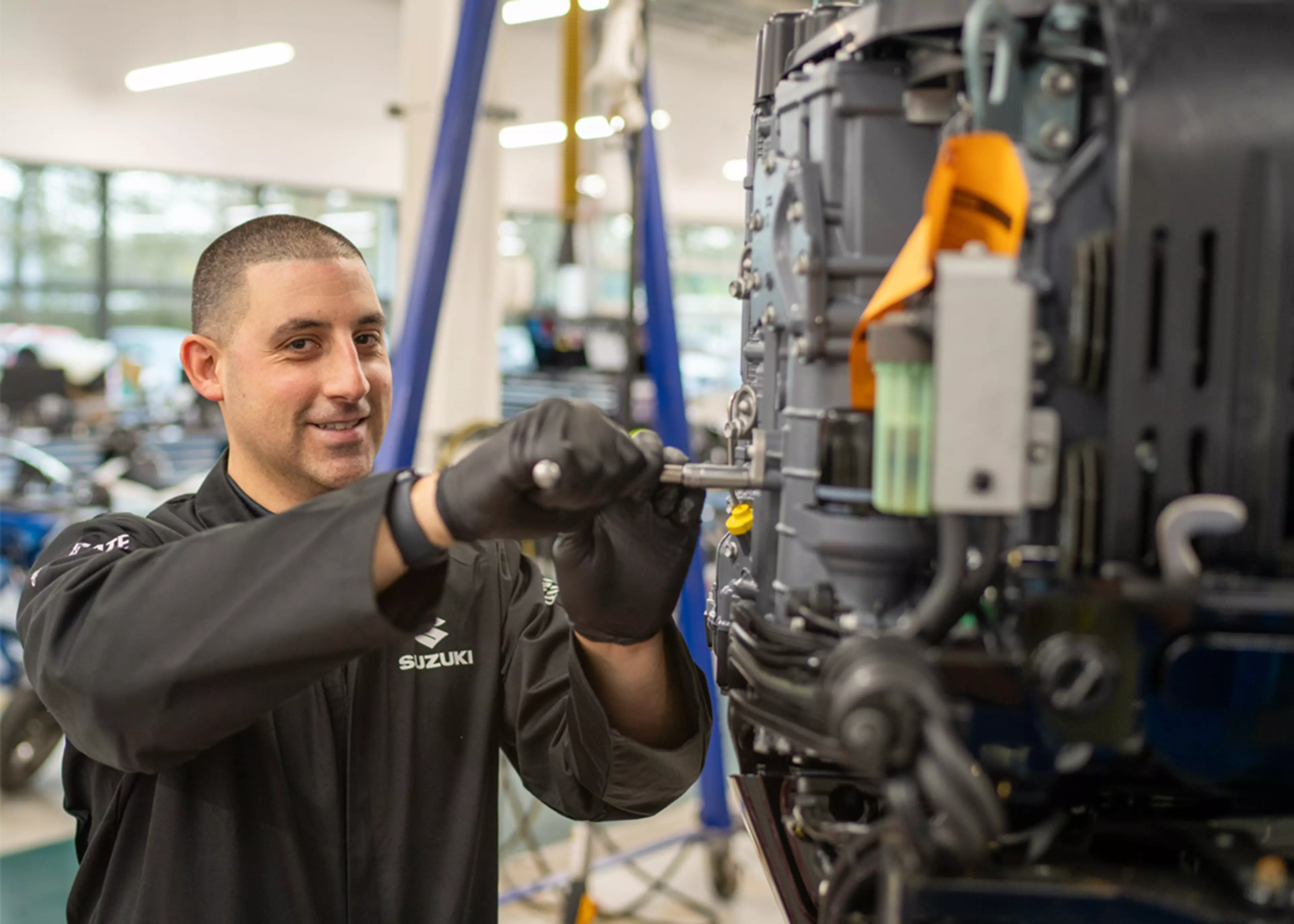 Suzuki engineer servicing a Suzuki outboard