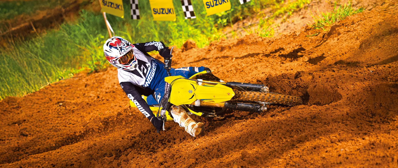 Suzuki RM-Z250, yellow leaning heavily into a corner on a Motorcross track