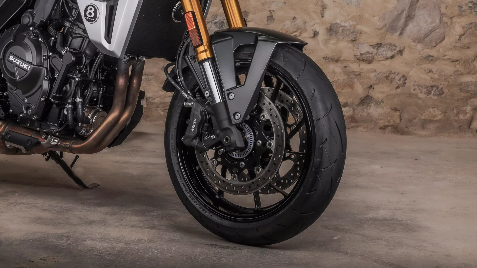 Suzuki GSX-8T front wheel and suspension close up in a barn