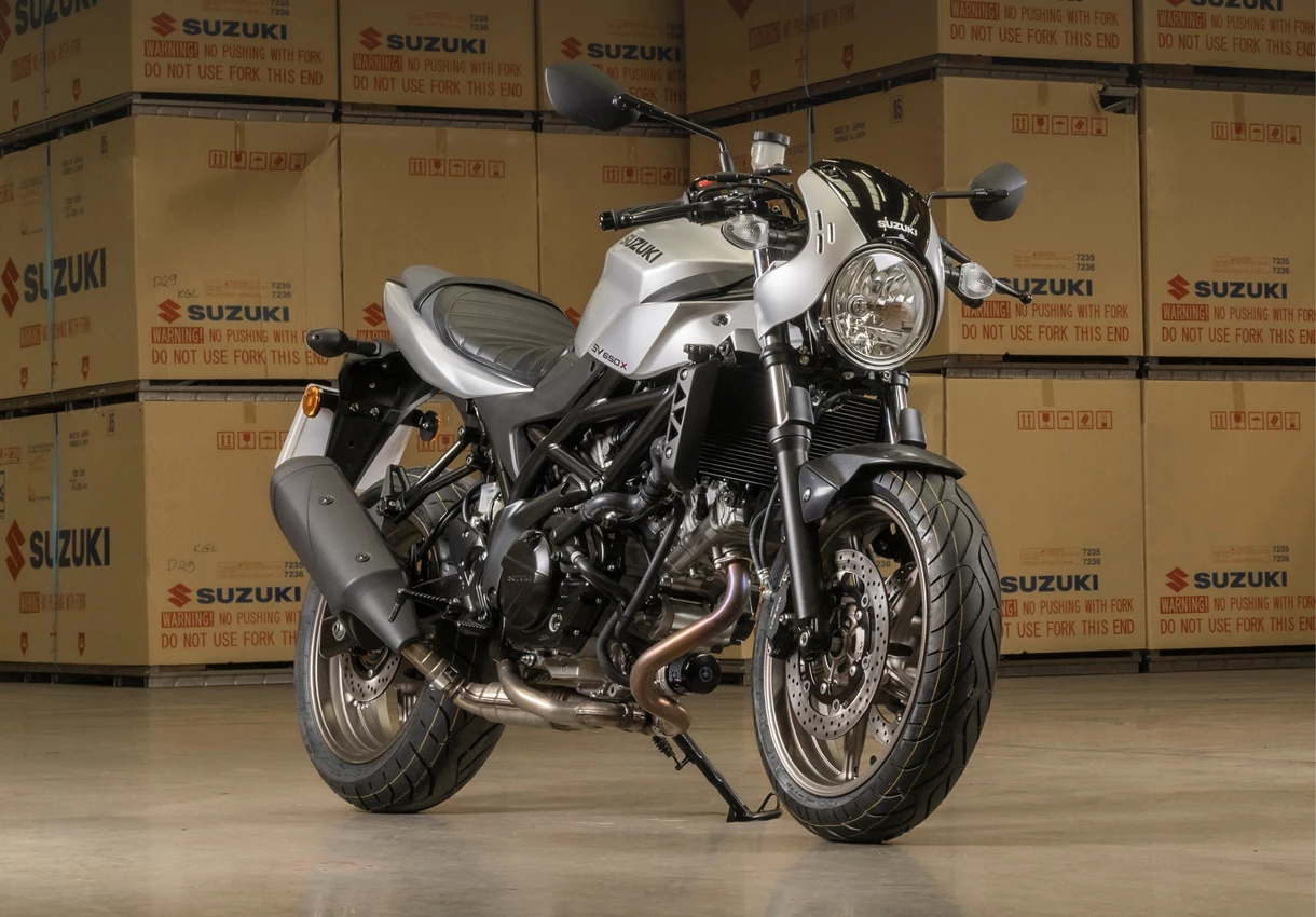 Suzuki SV650X static front three quarters with Suzuki crates in a warehouse in the background