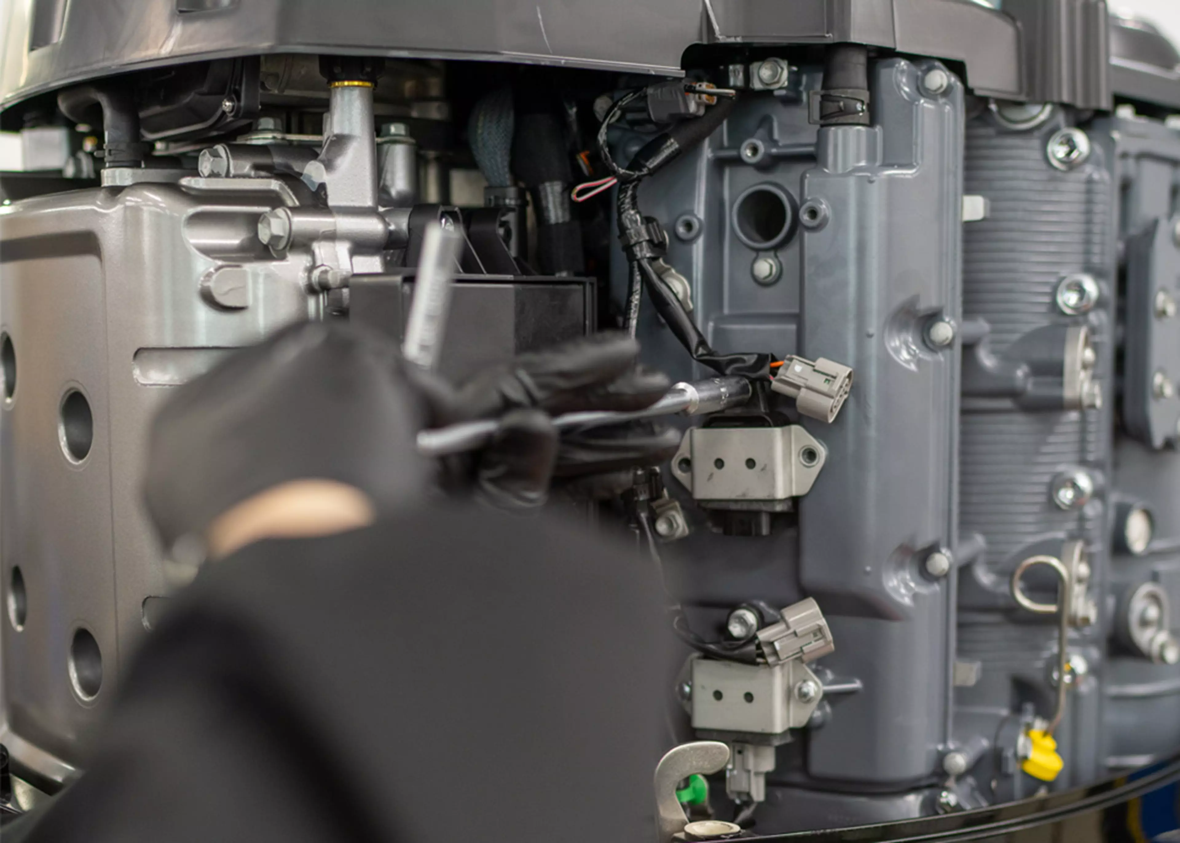 Suzuki engineer servicing a Suzuki outboard and removing spark plugs