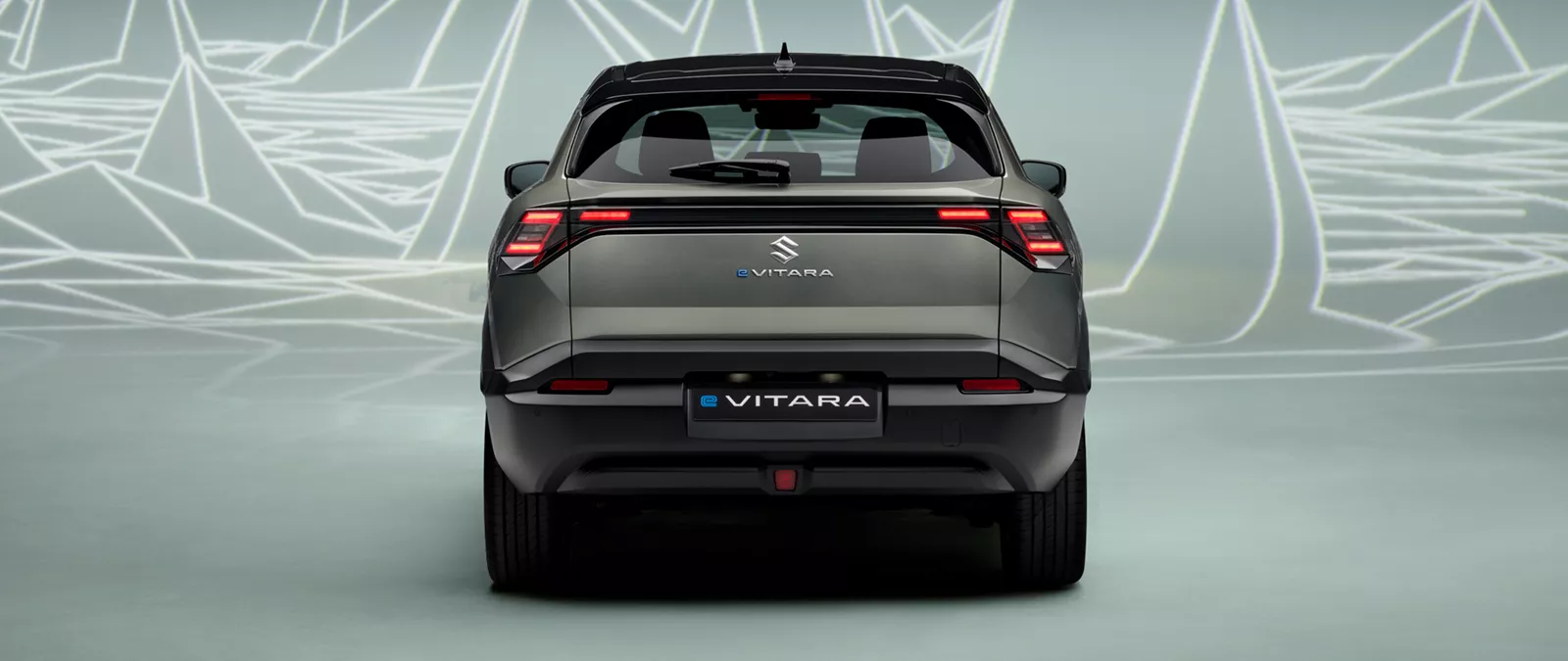 Straight rear view of the Suzuki e Vitara in Land Breeze Green Pearl Metallic, showcasing full-width LED tail lights