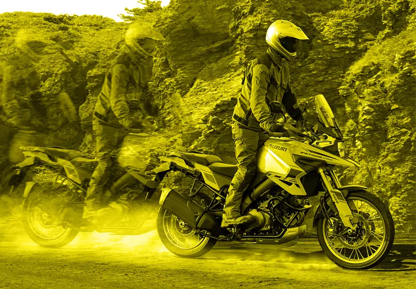 Suzuki V-Strom 1050DE Tour rider up on the pegs on a dirt track