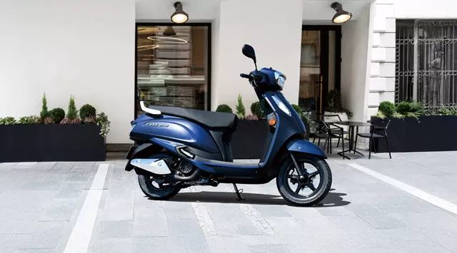 Suzuki Address 125 static with a cafe in the background