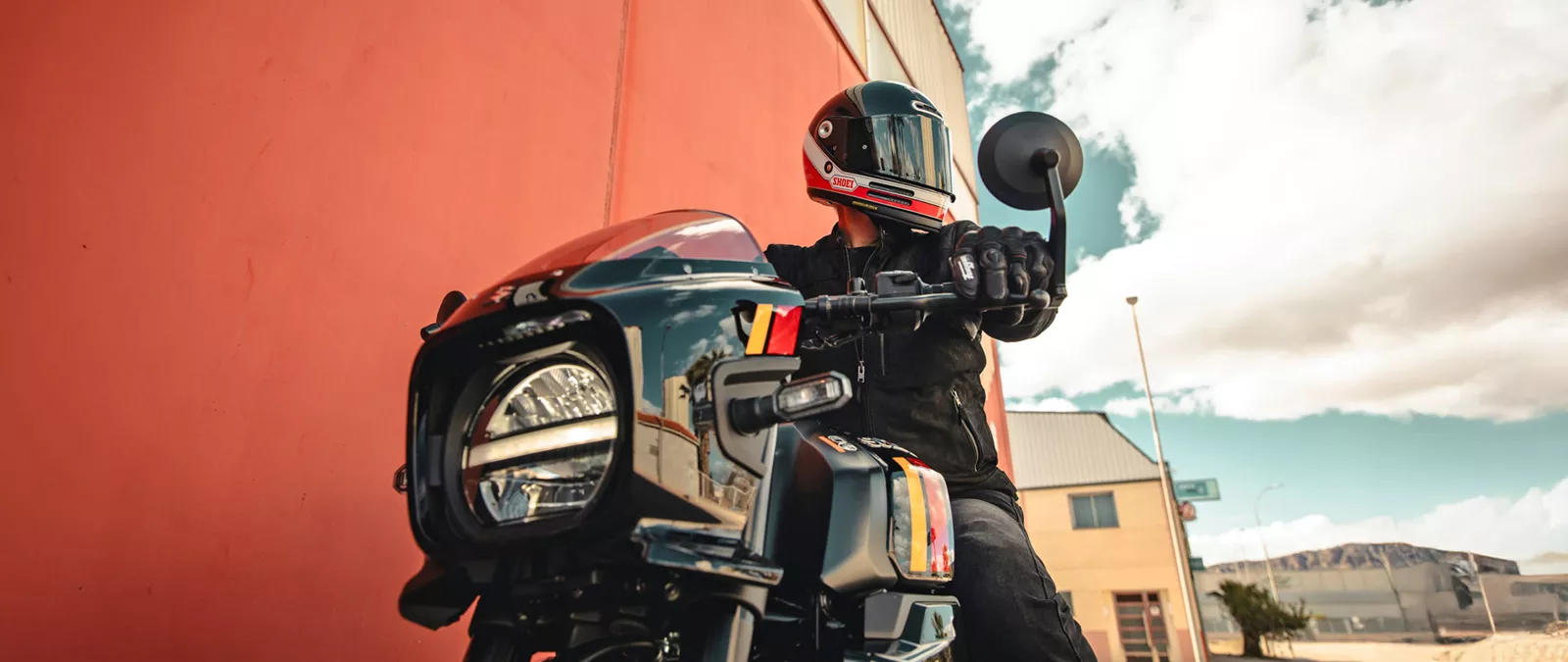 Suzuki GSX-8TT black with a rider close up of the front headlight and bar end mirror