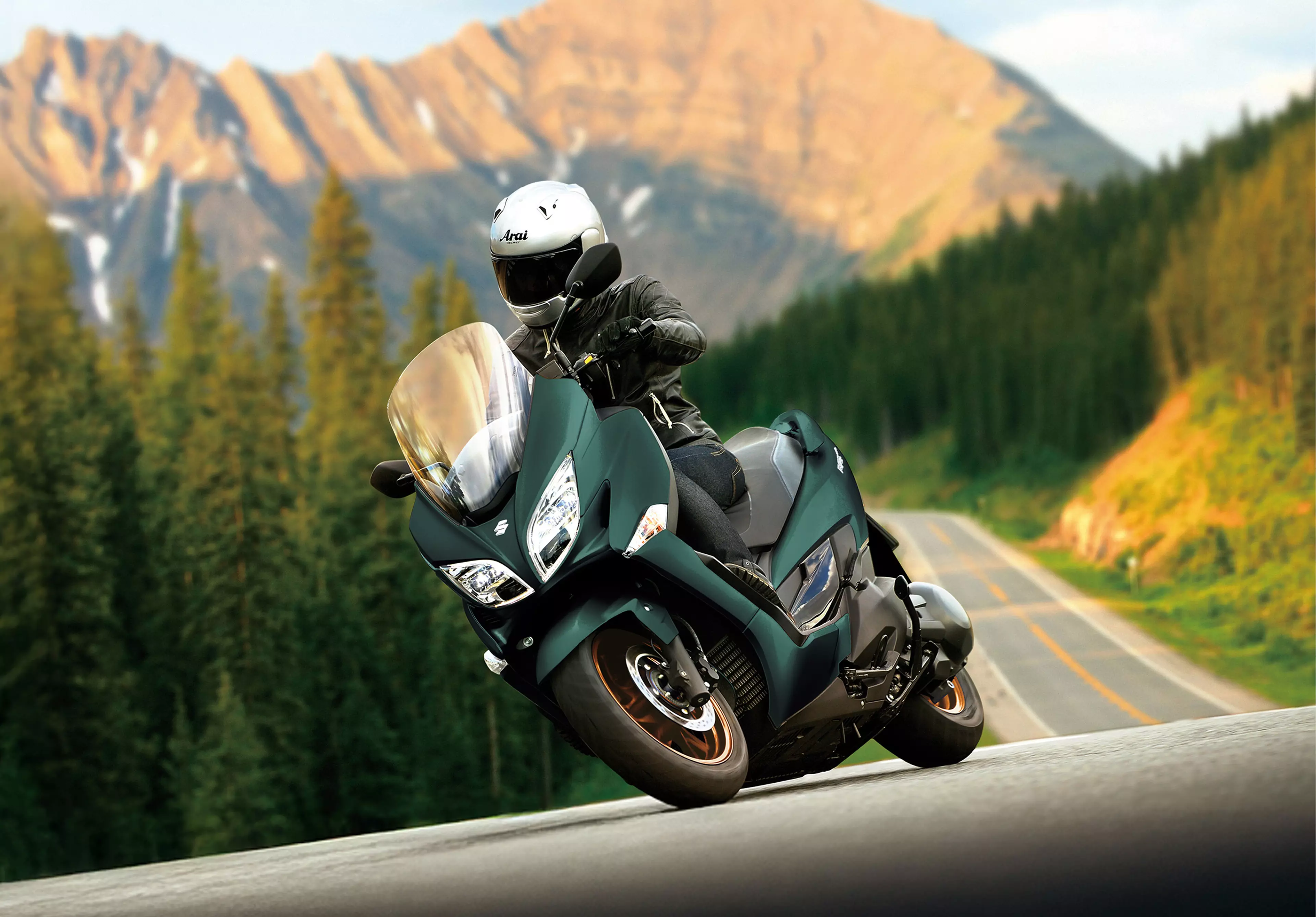 Suzuki Burgman 400 leaning gently into a corner on a mountain road. 