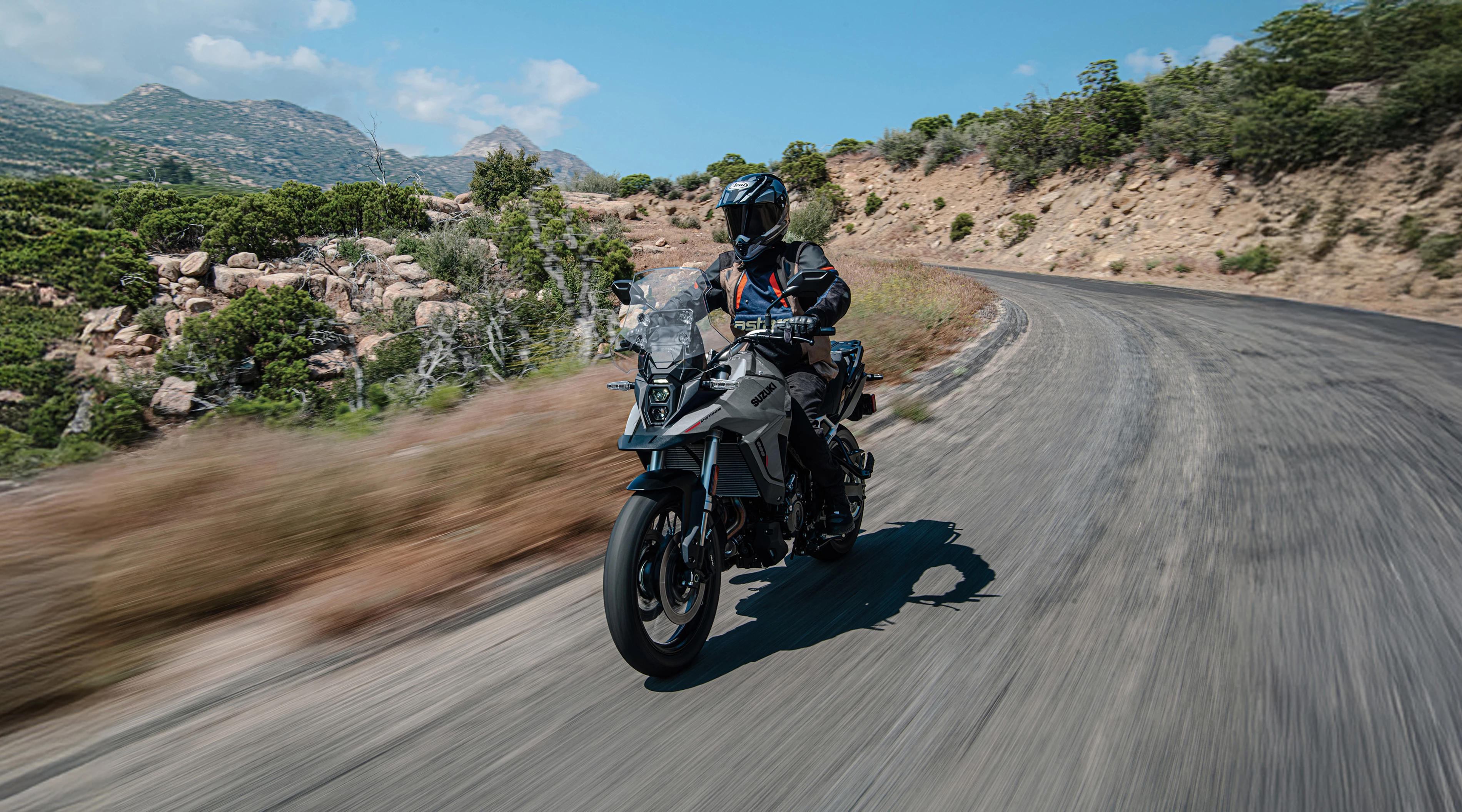 Suzuki V-Strom 800RE riding along a mountain road.