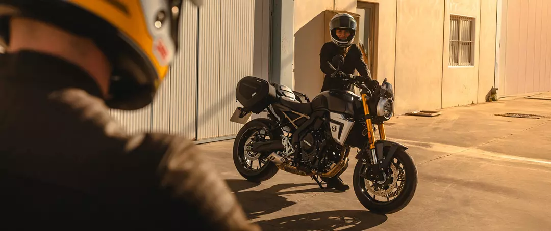 Suzuki GSX-8T over the should looking at the bike and another rider, static.