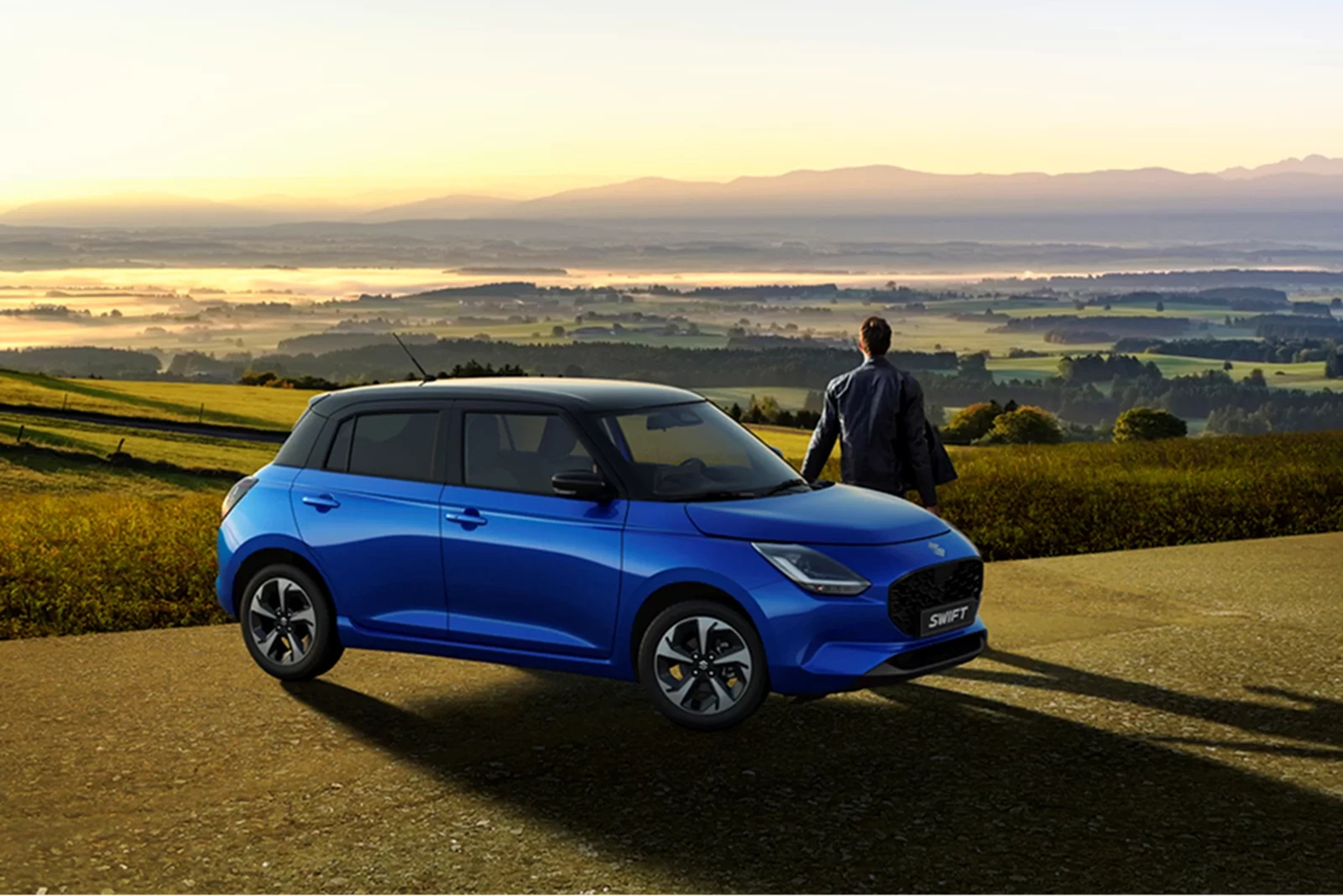 Frontier Blue Suzuki Swift parked at a scenic countryside viewpoint