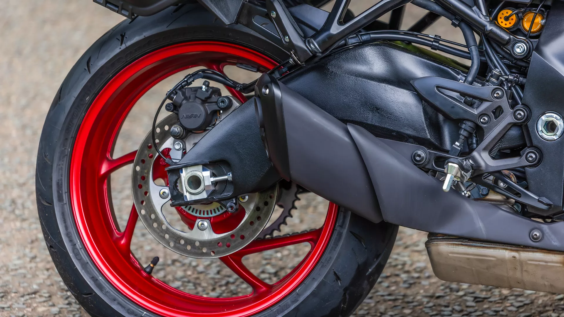 Suzuki GSX-S1000GX+ rear wheel and exhaust close-up.