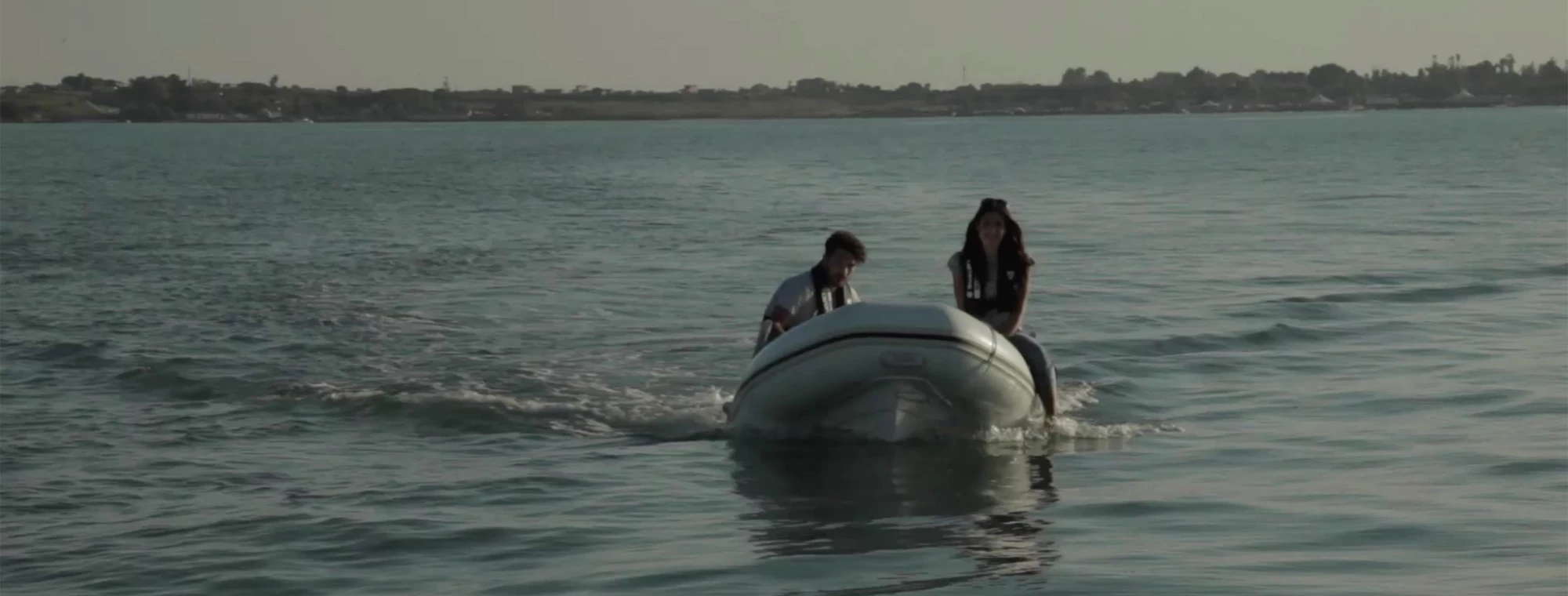 inflatable boat with two people heading to shore