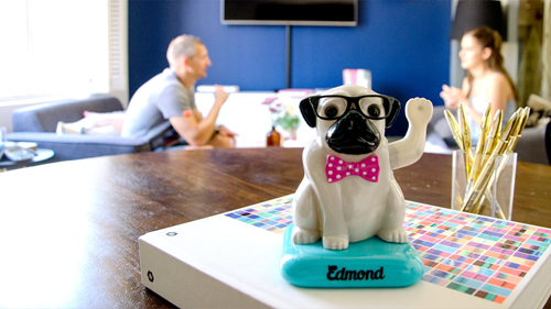 dog figurine waving. two colleagues in the background chatting