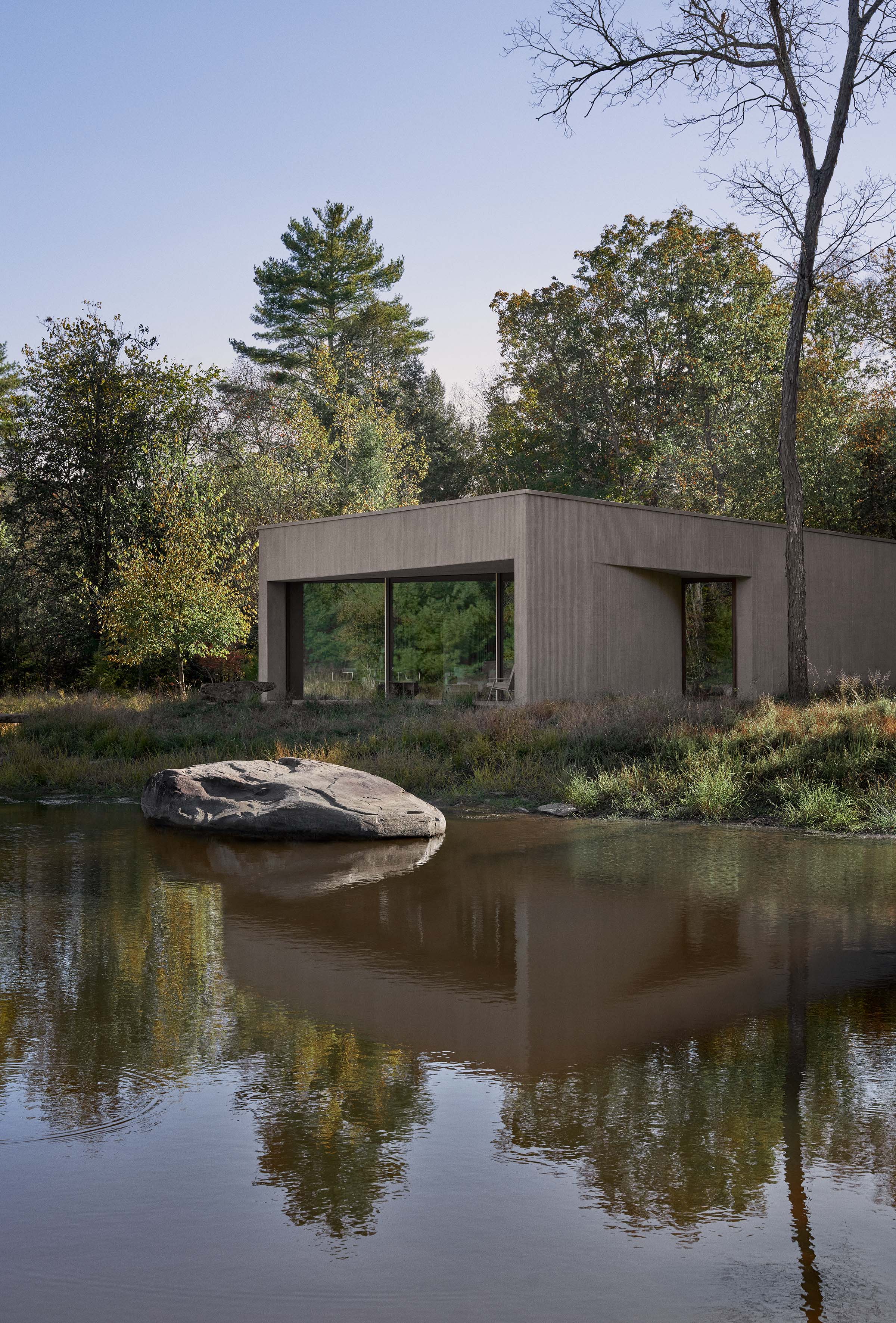 Exterior view of the Vipp Pavilion sitting low on the site with glass and dark cladding.