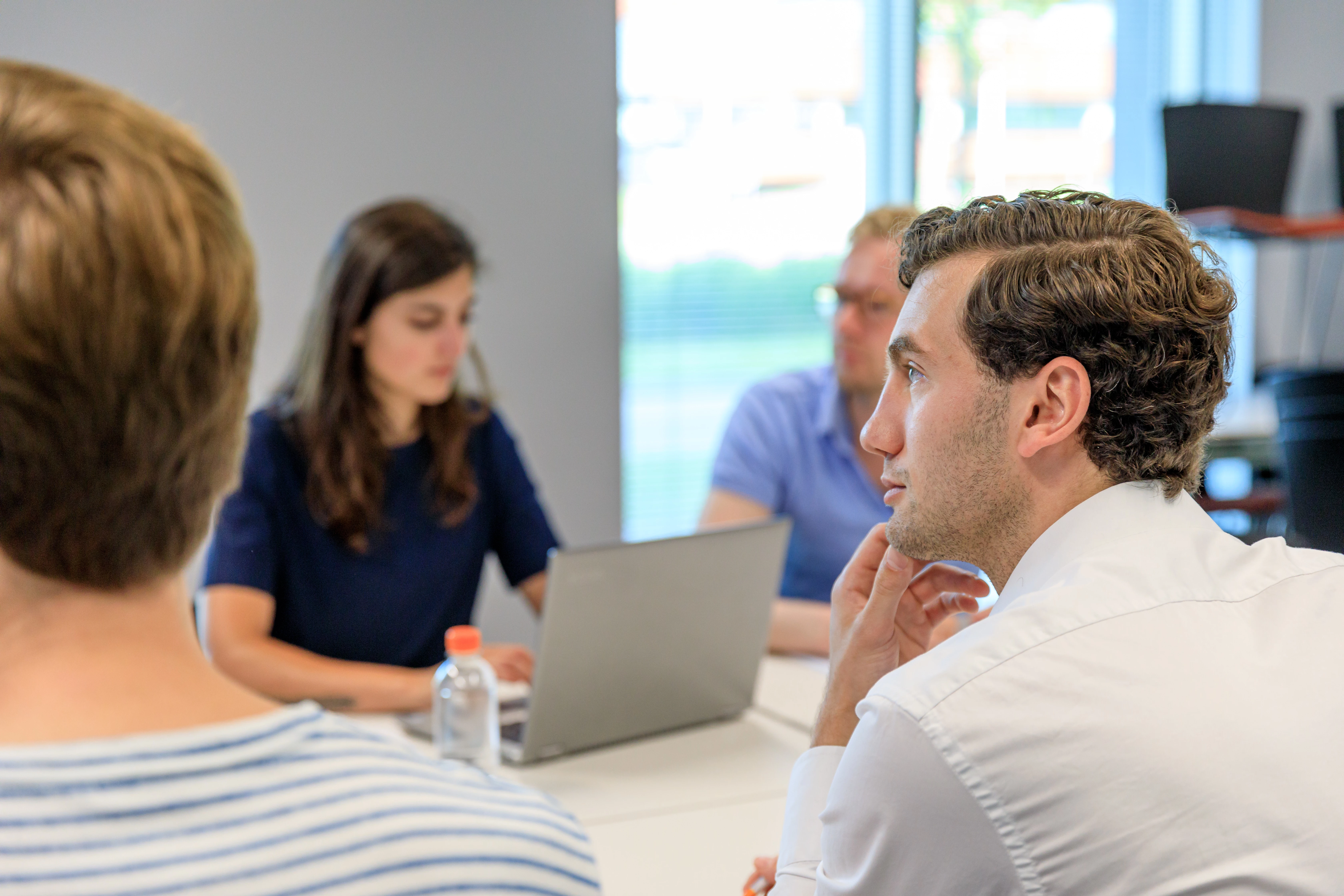 Een studentenraad komt bijeen met laptops om te vergaderen