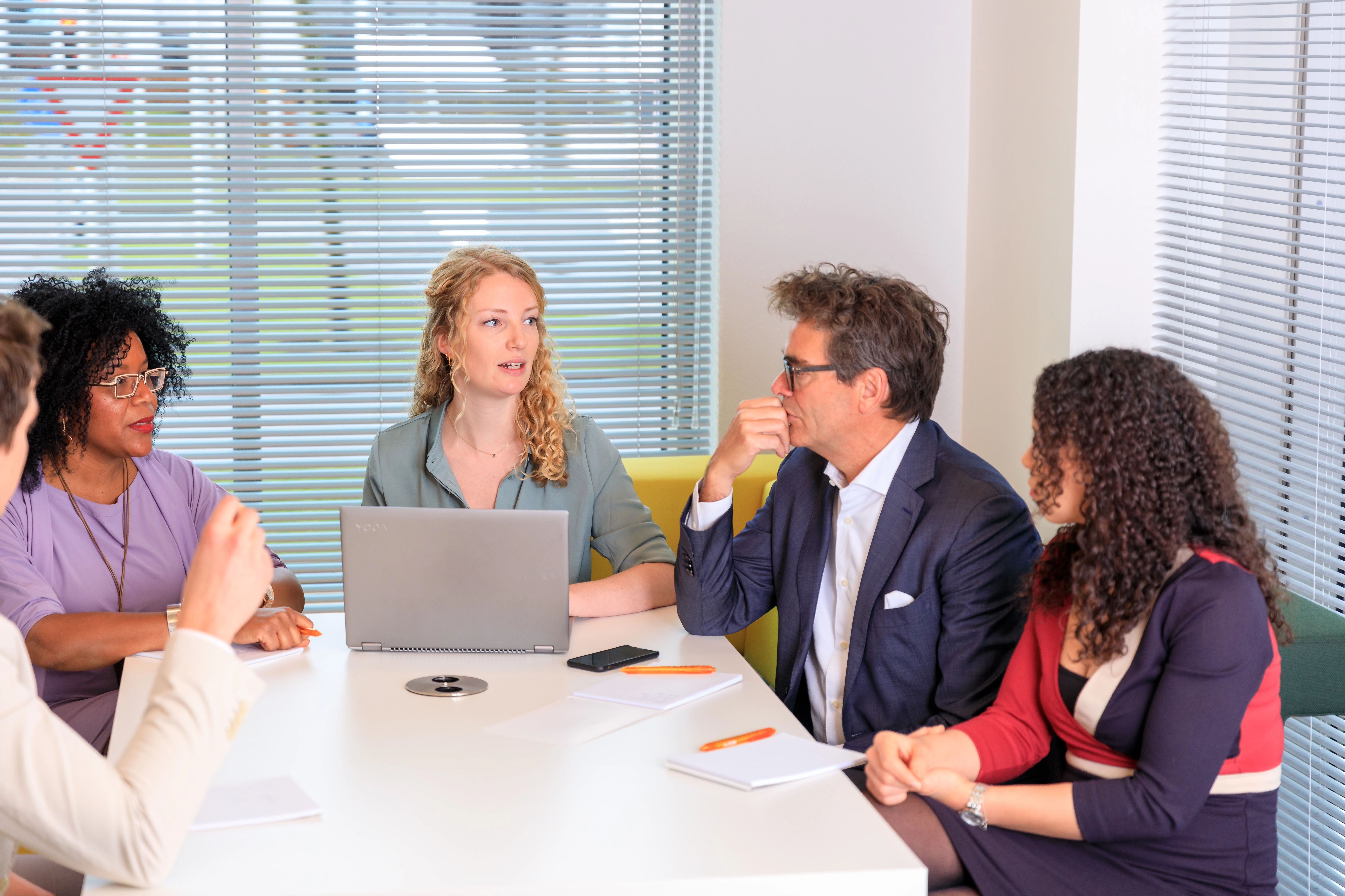 Een teamcoach begeleidt een team van vier collega's.