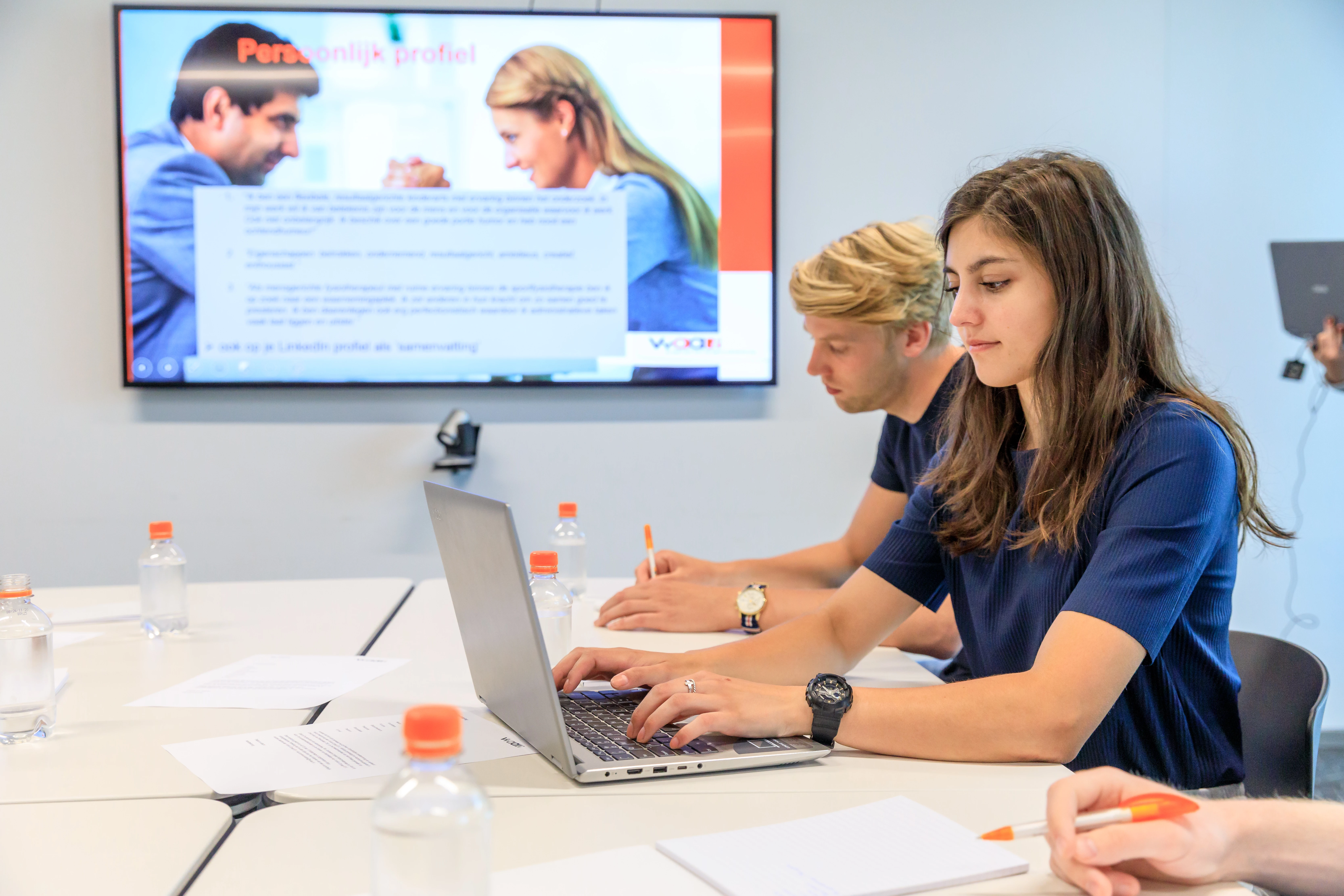 Studente zit achter laptop en bekijkt studentenverzekeringen