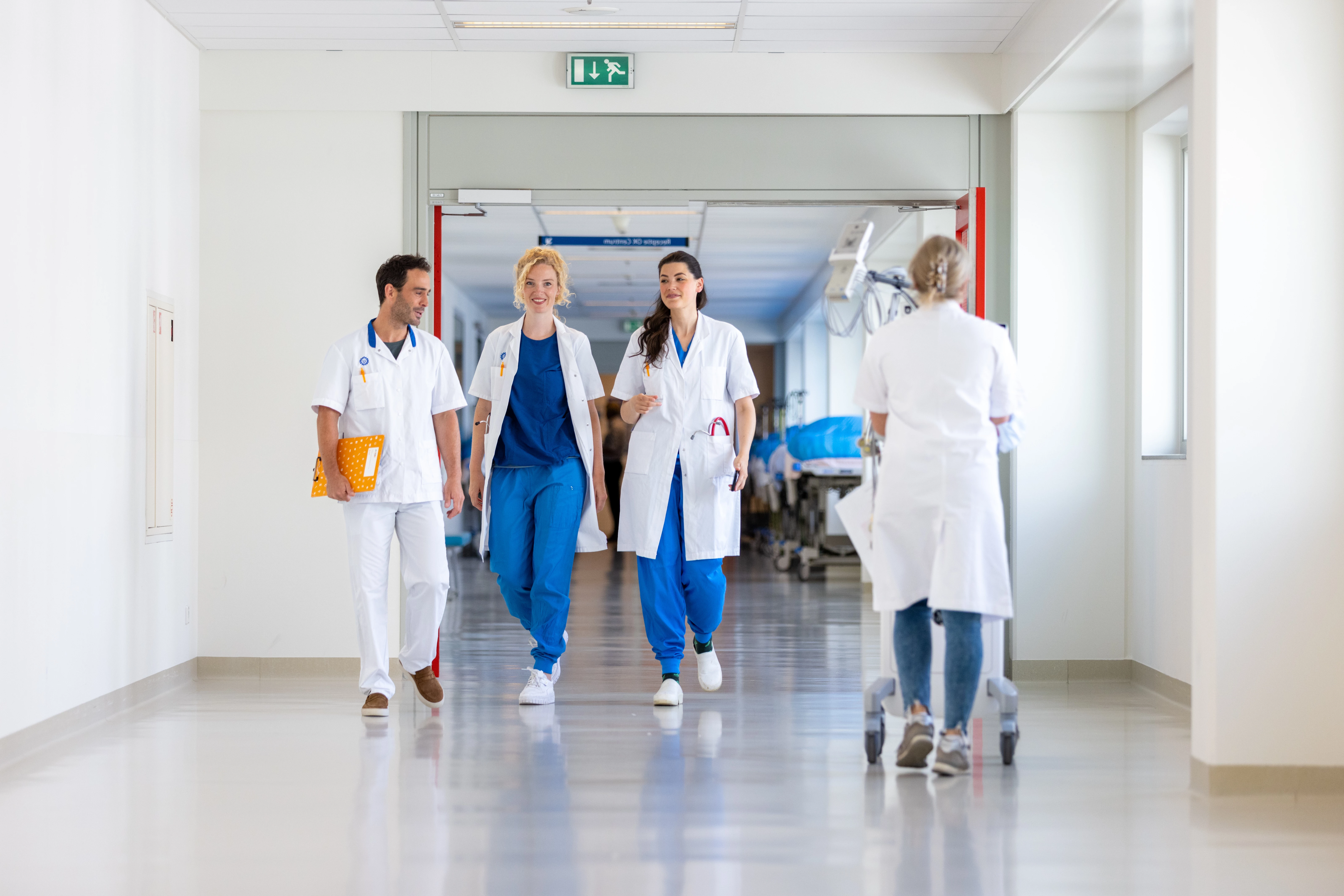 Medisch specialisten die door de gangen van een academisch ziekenhuis lopen.