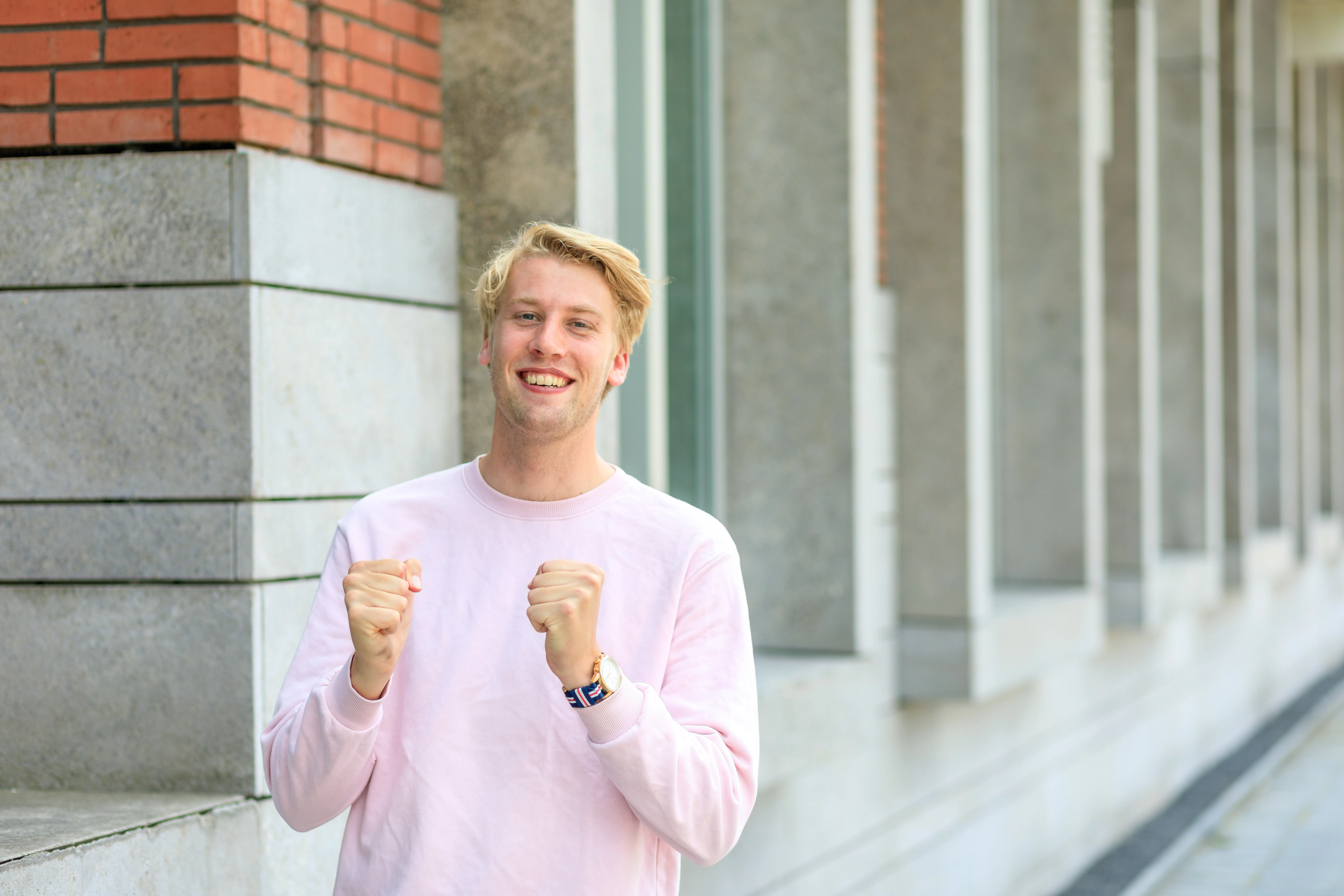 Mannelijke student staat buiten en lacht
