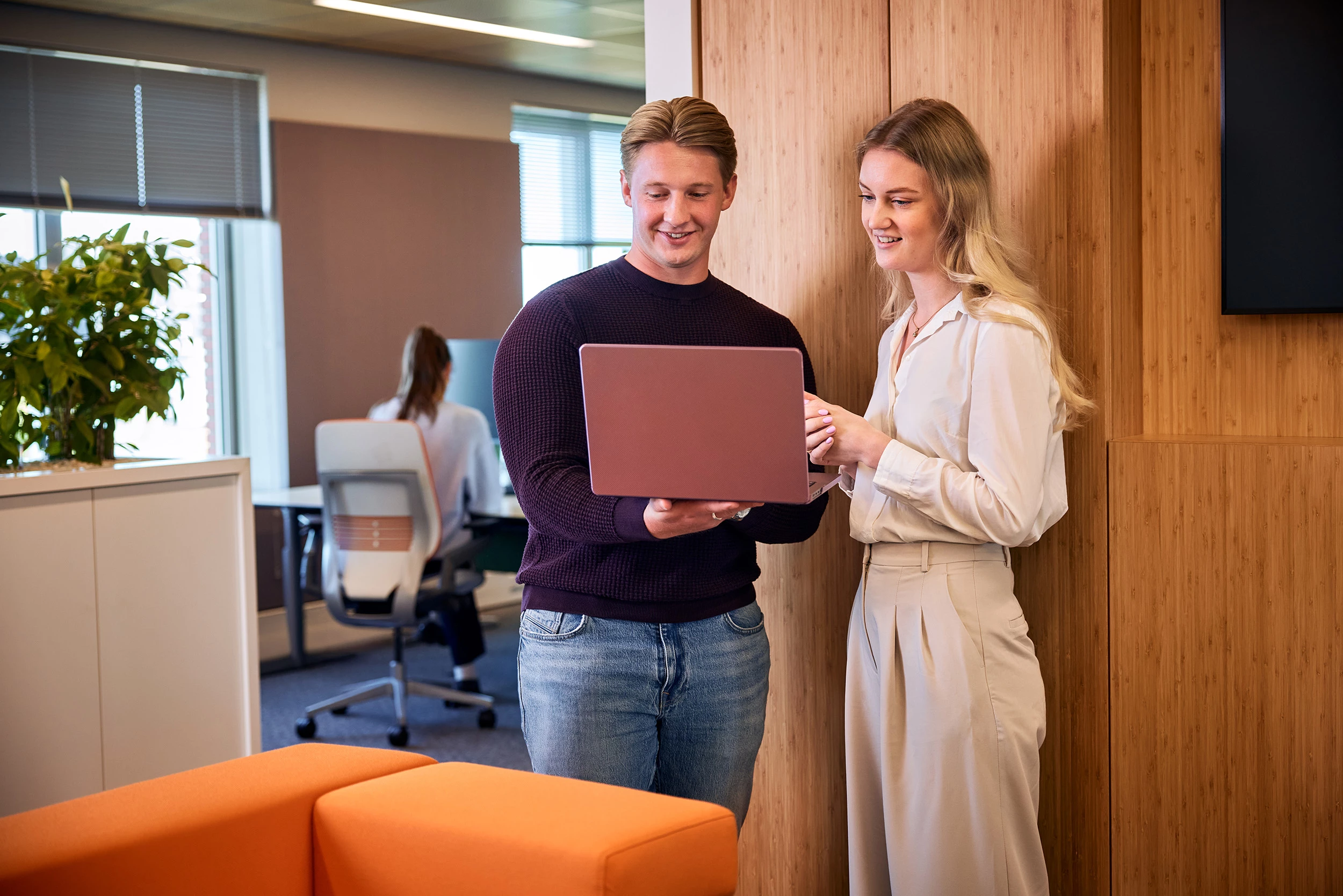 Man en vrouw kijken naar het beeldscherm van een laptop. 
