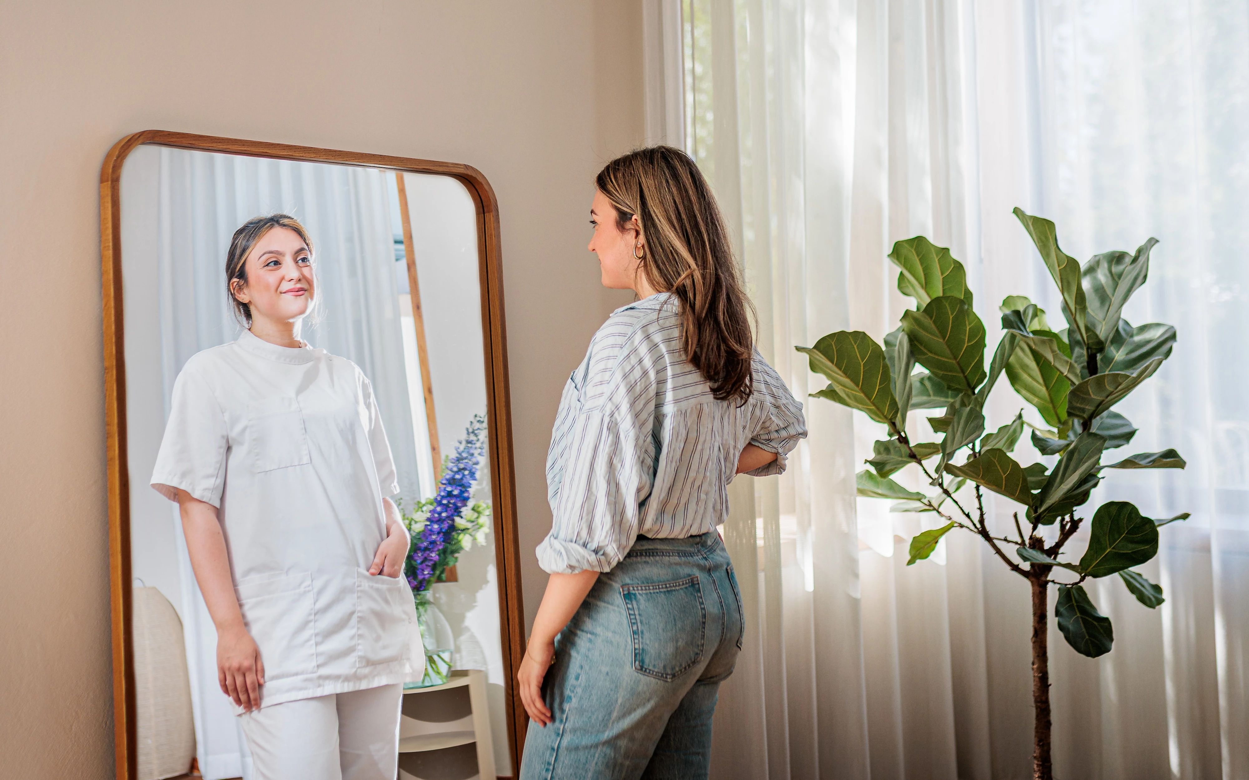 Startende zorgprofessional kijkt zichzelf aan in de spiegel