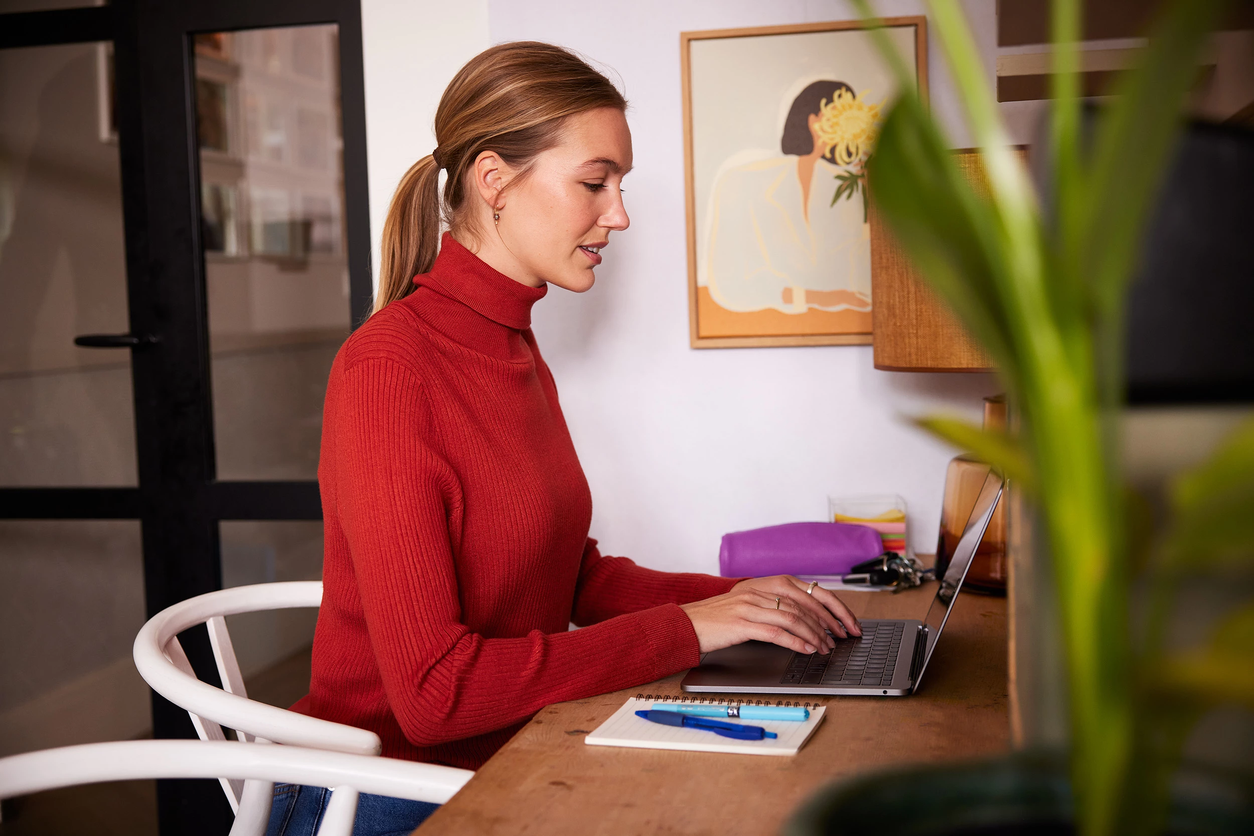 Zorgprofessional thuis zittend achter laptop