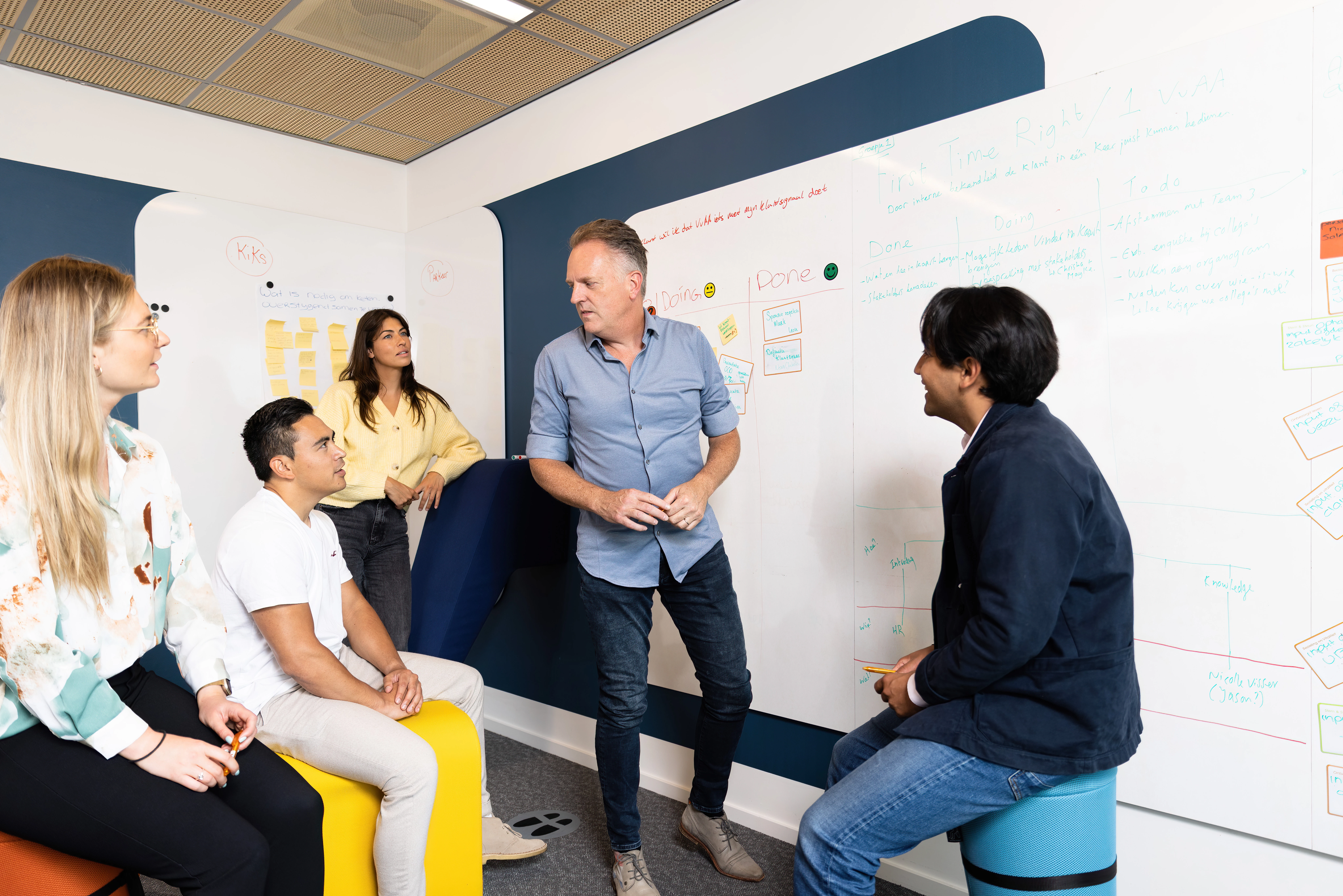 Brainstorm met 5 mensen bij whiteboard