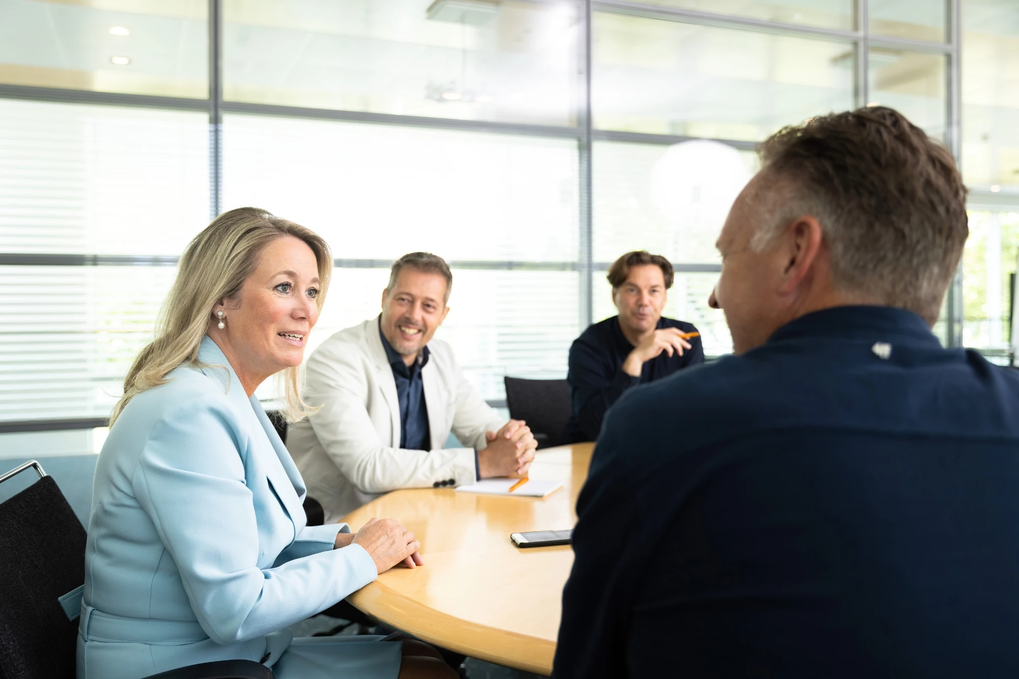 Jurist zit met adviseurs aan tafel in kantoor - VvAA Legal Advocatenkantoor Zorg