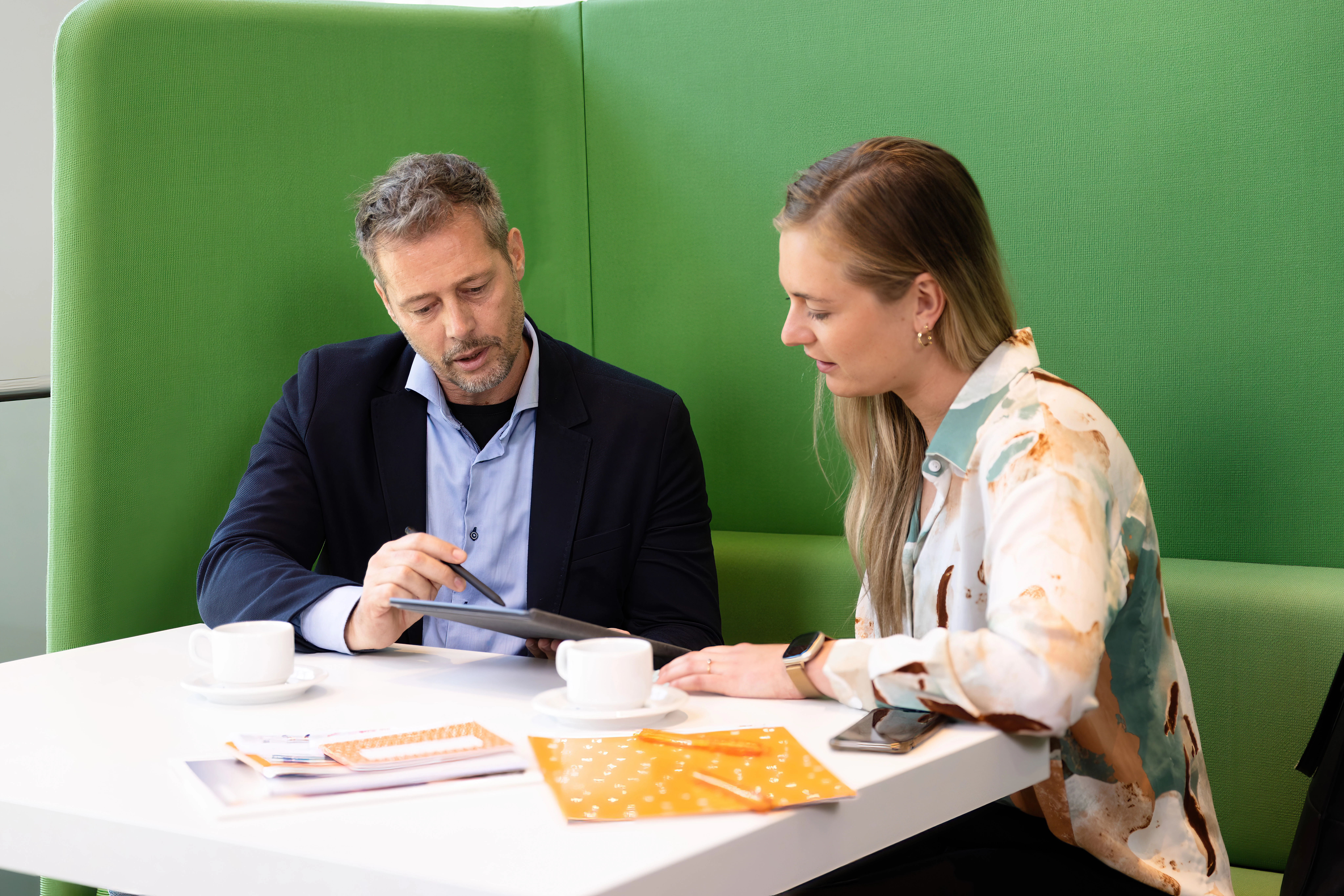 Adviseur en zorgverlener bespreken een letselschade om deze met zorg af te handelen.