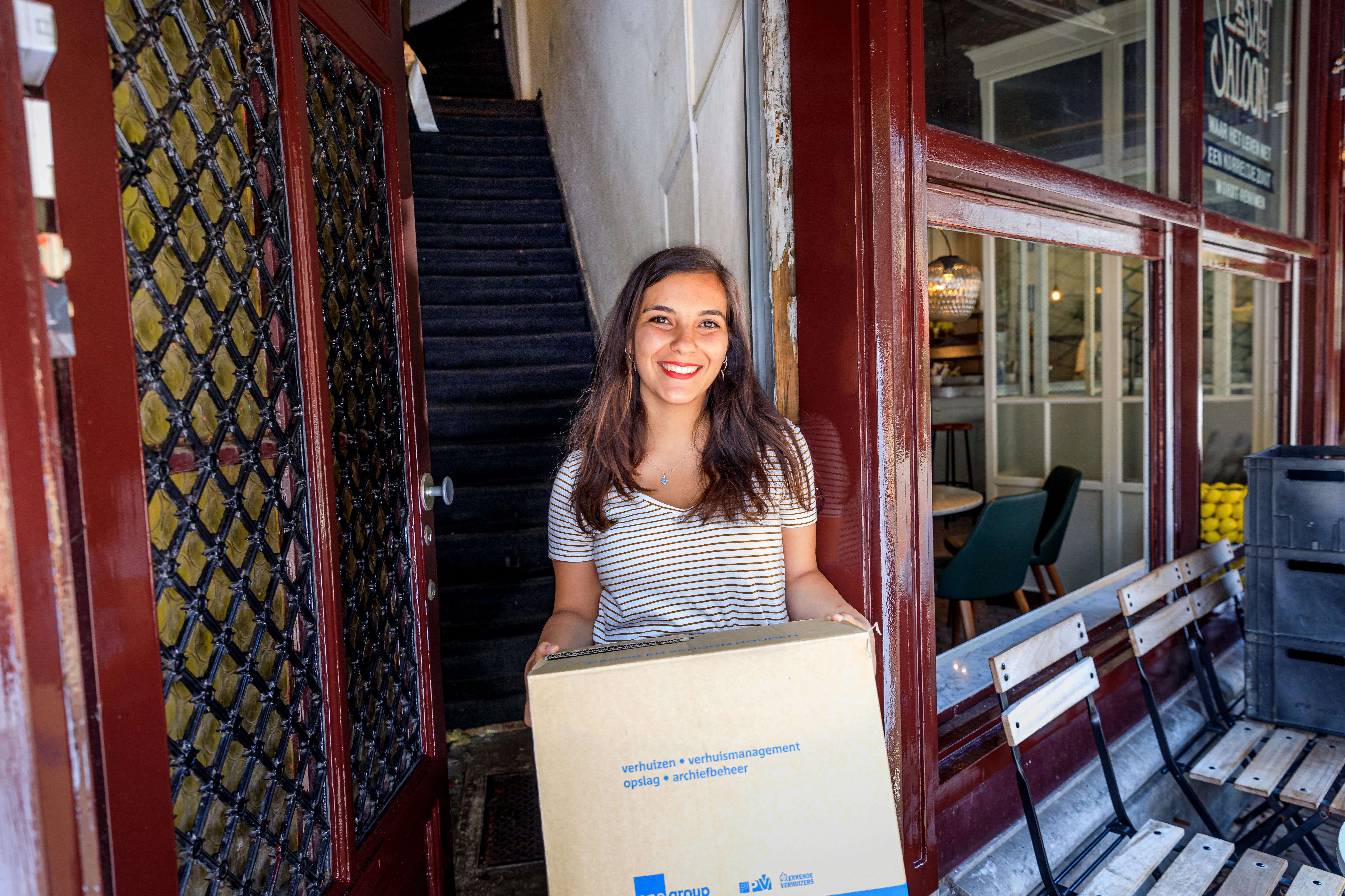 Student met verhuisdoos in deuropening