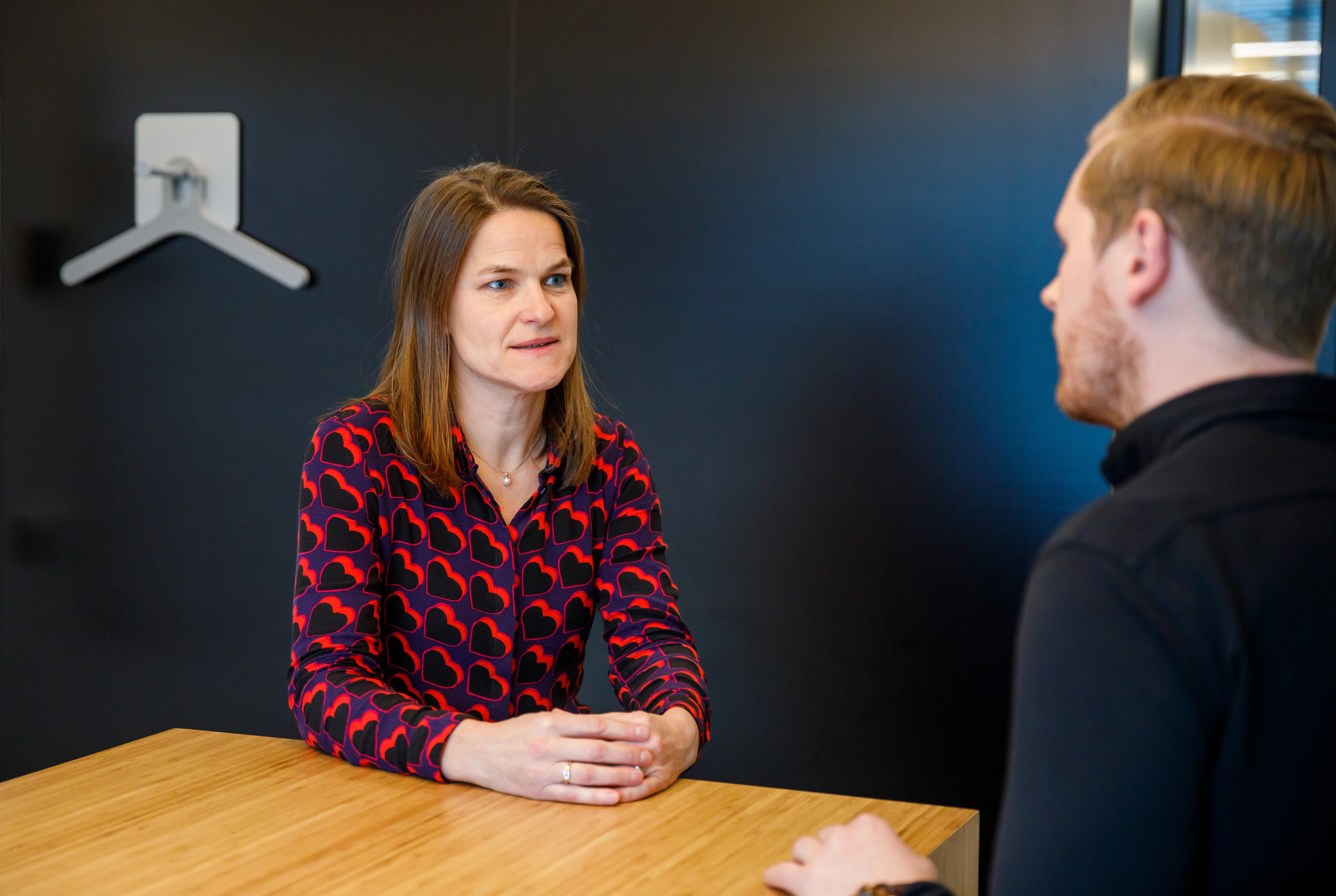 Vrouw voert gesprek met man aan een tafel