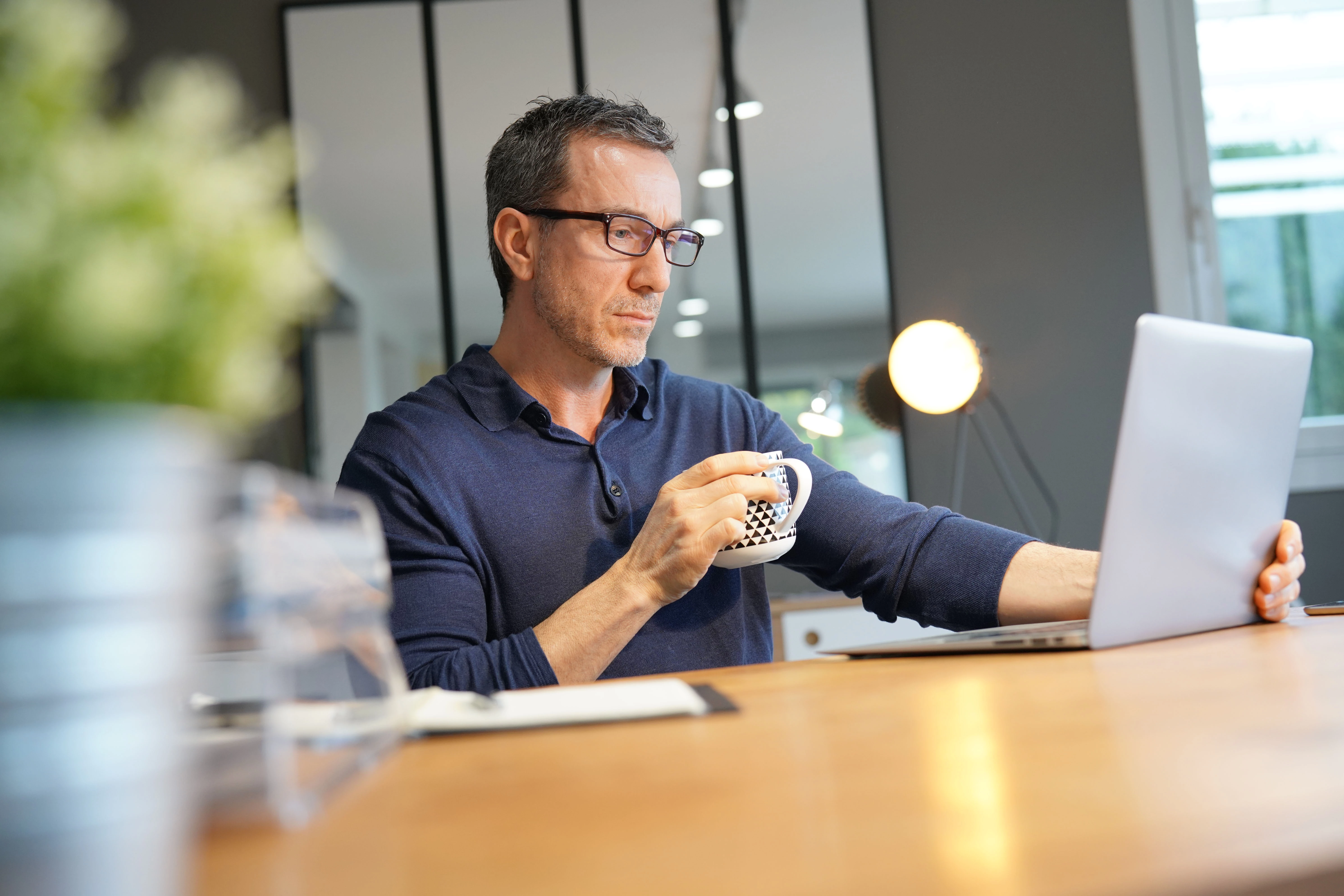 Een man kijkt op zijn laptop en sluit een verplichte AOV af