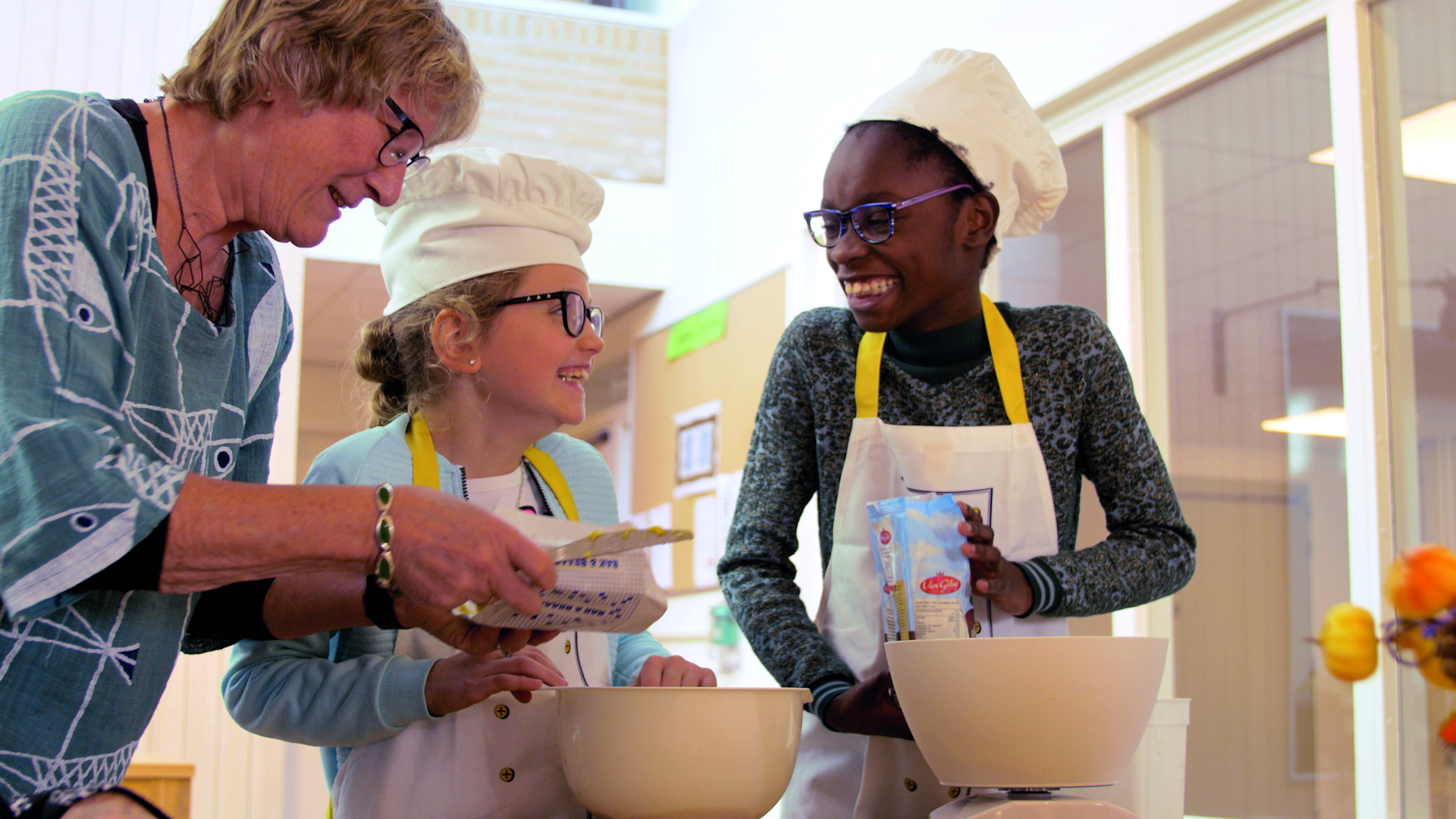 Senior huurder bakt taartjes met buurtkinderen