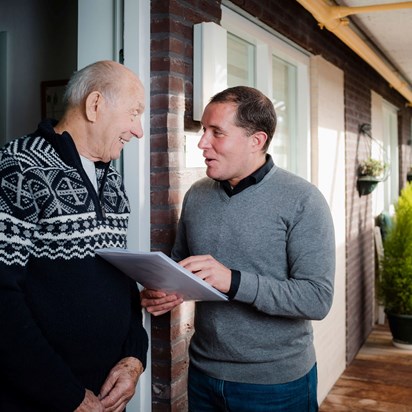 Bewonersconsulent Woonzorg Nederland in gesprek met seniore huurder